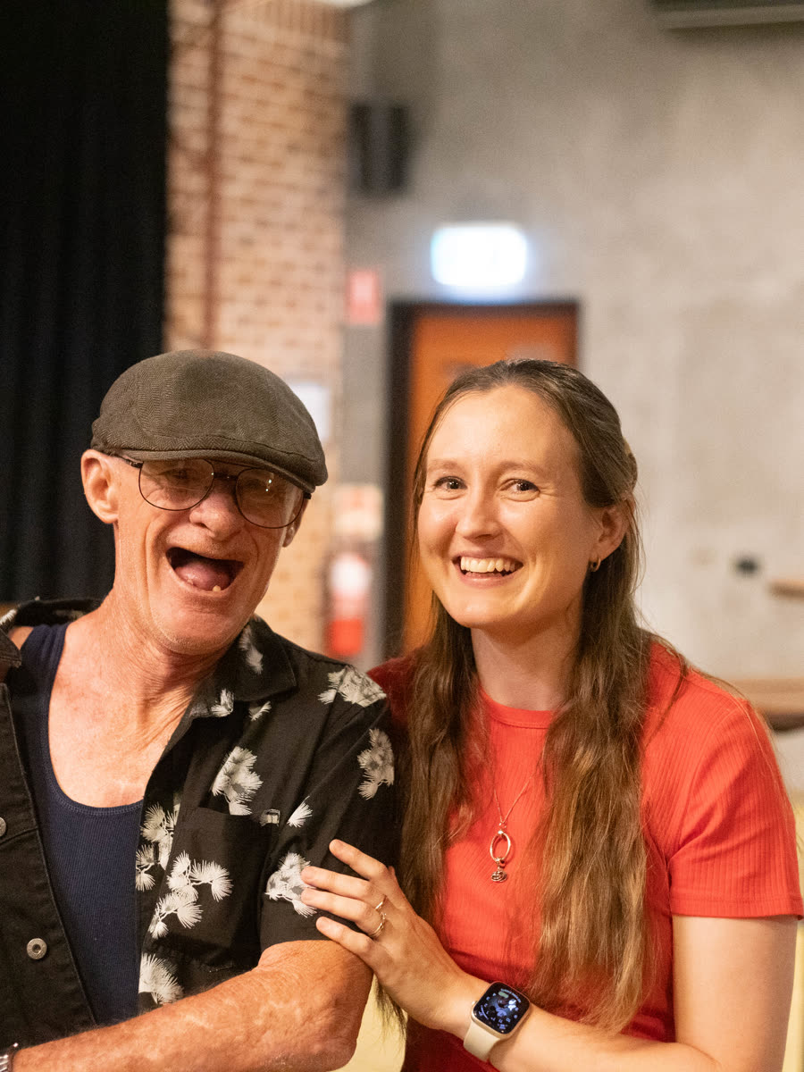 Two friends laughing together at a community event