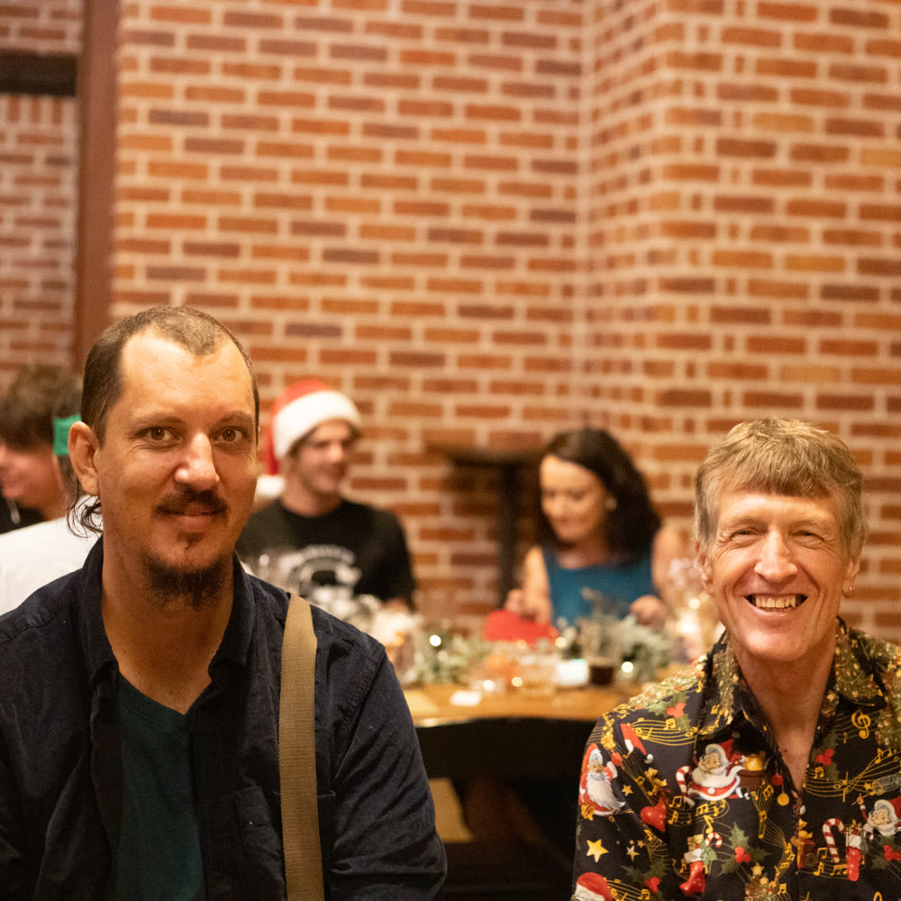 Two friends in festive shirts at the Christmas dinner