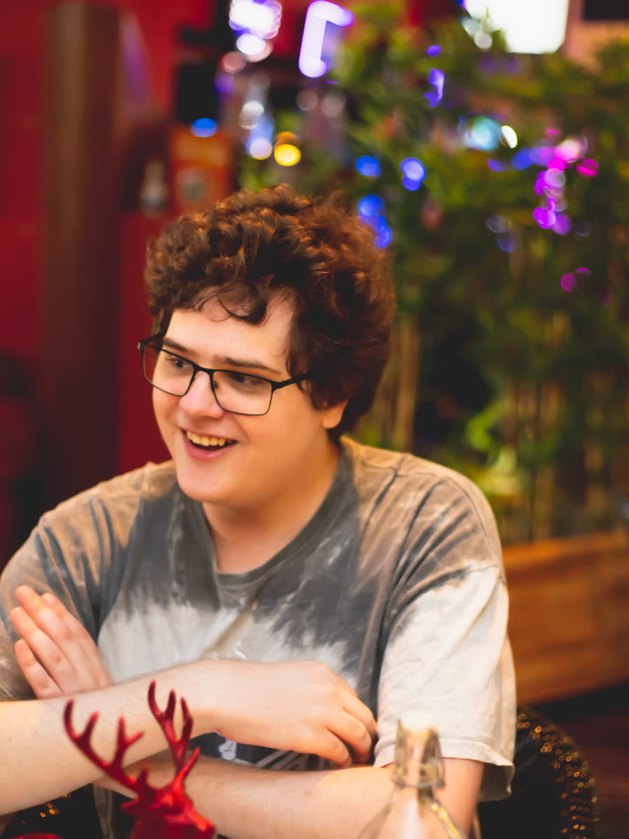 Young man laughing at a café catch-up